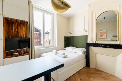 - une petite chambre avec un lit et une cheminée dans l'établissement COZETT'HOME - STUDIO Chics & Modernes - 2 pas du Cirque Jules Verne -, à Amiens
