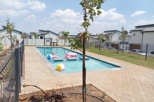 a swimming pool with toys in it with a tree at Jackal Creek Golf Estate- Luxury comfortable home in Roodepoort