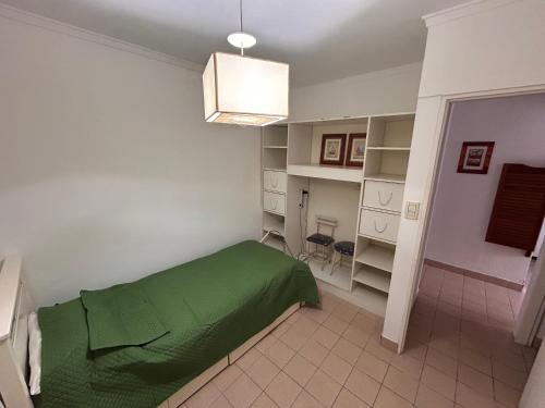 Un dormitorio con una cama verde en una habitación. en Girasoles Serranos, en Tandil