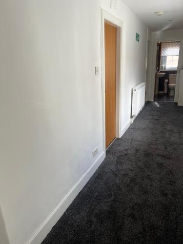 an empty room with white walls and a hallway at Gogarstone Cottage in EDI