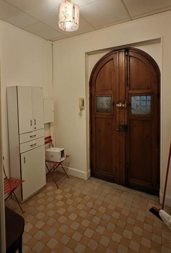 Il comprend une cuisine équipée d'un réfrigérateur et une porte en bois. dans l'établissement Appartement 50m2 proche mer, à Nice