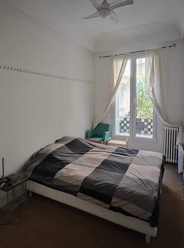 une chambre avec un grand lit et une fenêtre dans l'établissement Appartement 50m2 proche mer, à Nice