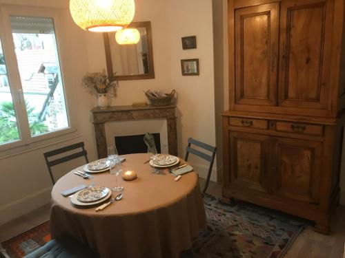 Appartement ancien cosy في دْييب: غرفة طعام مع طاولة ومدفأة