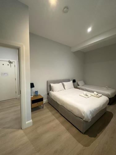 a bedroom with a large white bed and a table at Abbey Apartments in Dublin
