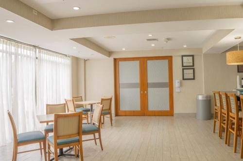 a waiting room with tables and chairs and a door at Hampton Inn Jacksonville South/I-95 at JTB in Jacksonville