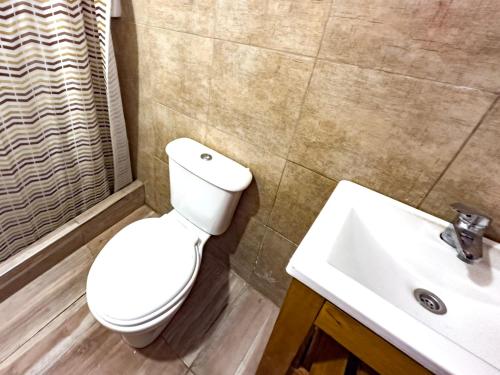 a bathroom with a toilet and a sink at Bavarian Suites in Colón