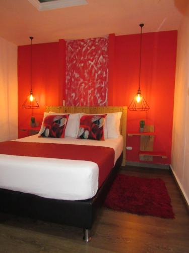 um quarto com uma cama grande e paredes vermelhas em The Garden Lleras 10 em Medellín
