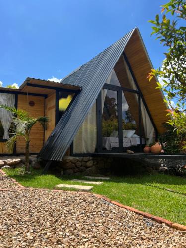 a house with a black roof and windows at Glamping Pozo Azul, Villa de Leyva in Villa de Leyva