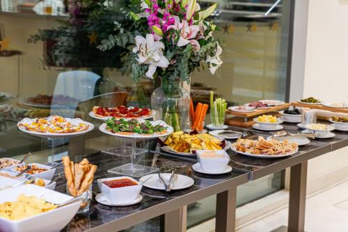 a buffet with many plates of food on a table at Art Hotel Navigli in Milan