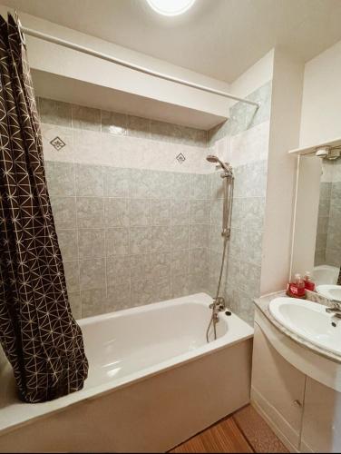 une salle de bain avec une baignoire et un lavabo dans l'établissement Chez Lauriane et Yannick appartement 6 pers la Joue du Loup centre, à Saint-Étienne-en-Dévoluy