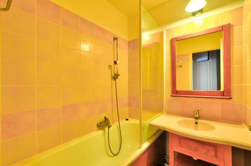 une salle de bain avec une baignoire, un lavabo et un miroir dans l'établissement La résidence du Lac - maeva Home - Appartement 2 pièces 4 personnes - Sélection MAE-4791, à Monflanquin