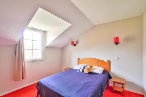 une chambre avec un lit avec une couette bleue et une fenêtre dans l'établissement La résidence du Lac - maeva Home - Appartement 2 pièces 5 personnes - Sélection MAE-5801, à Monflanquin