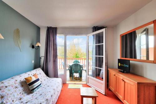 un salon avec un canapé et une porte coulissante en verre dans l'établissement La résidence du Lac - maeva Home - Appartement 2 pièces 4 personnes - Sélection MAE-5811, à Monflanquin