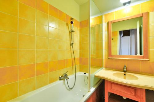 une salle de bain avec une baignoire, un lavabo et un miroir dans l'établissement La résidence du Lac - maeva Home - Appartement 2 pièces 4 personnes - Sélection MAE-5811, à Monflanquin
