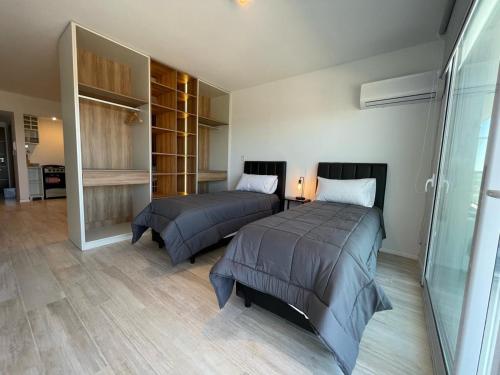 a bedroom with two beds and a walk in closet at Apartamentos Belgrano Luxury in Neuquén