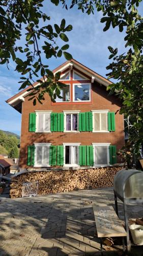 a house with green and white shutters on it at Private Room in an old Farmhouse near Vaduz in Sevelen
