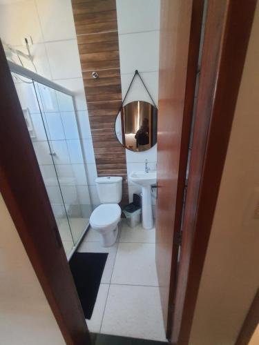 a bathroom with a toilet and a mirror at Casa com piscina- condomínio verão vermelho II UNAMAR CABO FRIO in Cabo Frio