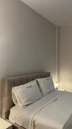 a large bed with white sheets and pillows at Hey Apartment 1 in Hamallë