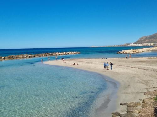 a group of people standing on a beach at Vida Rooms in Trapani