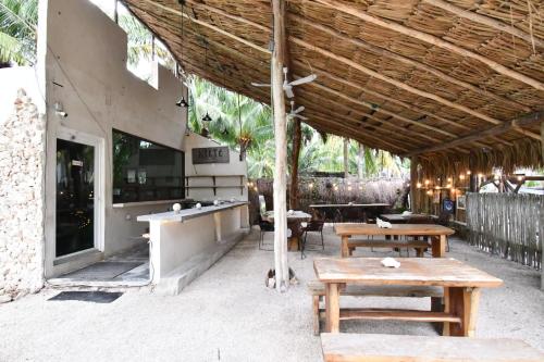 a patio with wooden tables and benches in a building at Casa Maria Bonita Hotel & Restaurant El Cuyo by Spot Rentals in El Cuyo