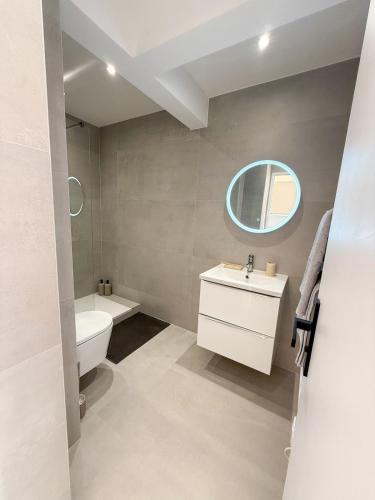 une salle de bain avec un lavabo, des toilettes et un miroir dans l'établissement Port de Nice, Appartement 4pers emplacement idéal tout équipé balcon, à Nice