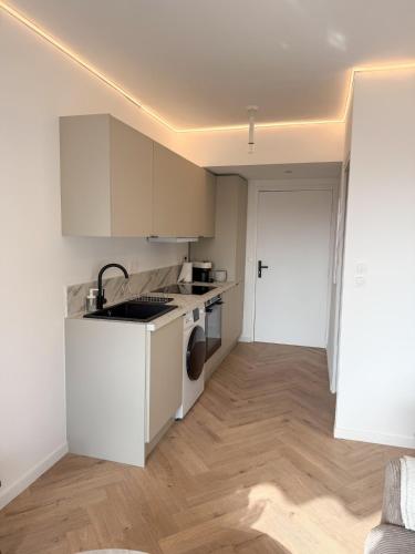 une cuisine blanche avec un évier et un lave-vaisselle dans l'établissement Port de Nice, Appartement 4pers emplacement idéal tout équipé balcon, à Nice