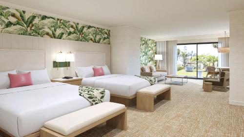 pokój hotelowy z dwoma łóżkami i salonem w obiekcie Tommy Bahama Miramonte Resort & Spa w mieście Indian Wells