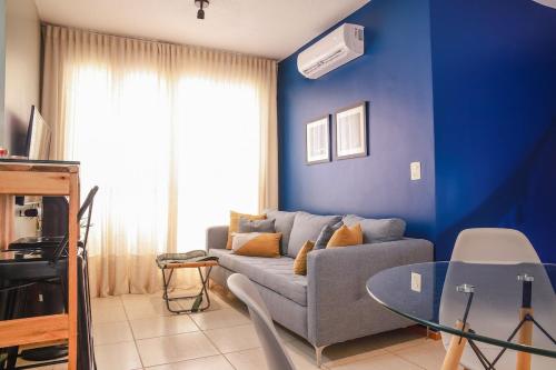a blue living room with a couch and a glass table at Apê de 3 quartos com ar-condicionado e Berço in Cuiabá