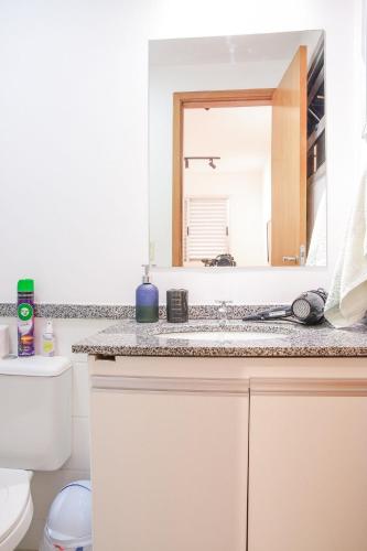 a bathroom with a sink and a mirror at Apê de 3 quartos com ar-condicionado e Berço in Cuiabá
