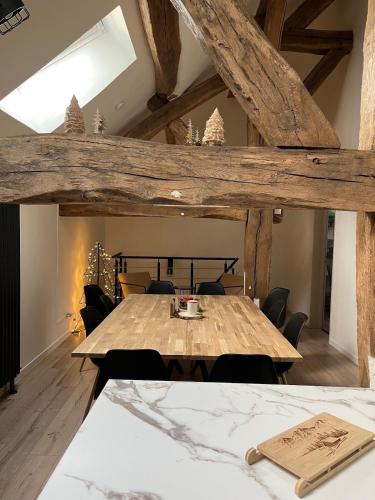 une salle à manger avec une table et des chaises en bois dans l'établissement Le Nichoir des Lacs, au coeur du pays des Lacs, Jura, à Barésia-sur-lʼAin