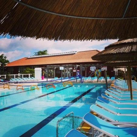 une grande piscine avec des chaises et un parasol dans l'établissement Le Cozy'Land - Mobilhome Camping La Réserve, à Gastes