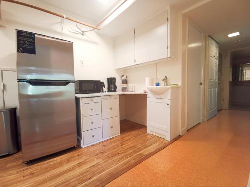 a kitchen with a stainless steel refrigerator and white cabinets at POWER ON - City Oasis in Issaquah