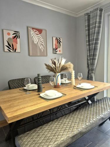 a dining room table with wine glasses on it at Large 3-Bed House Near Fosse Park - Free Parking in Leicester