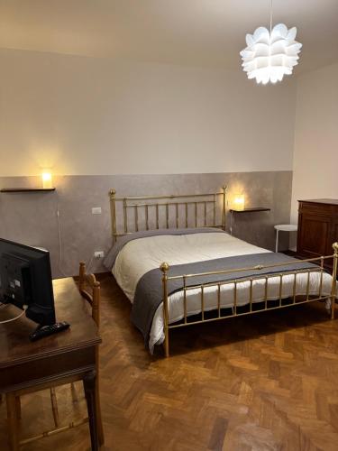 a bedroom with a bed and a desk and a television at Residenza Il Castello Uno e Due in CastellʼArquato