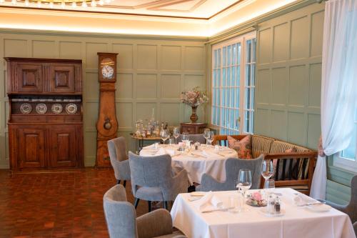 a dining room with tables and chairs and a clock at Romantik Hotel & Restaurant Sternen in Kriegstetten
