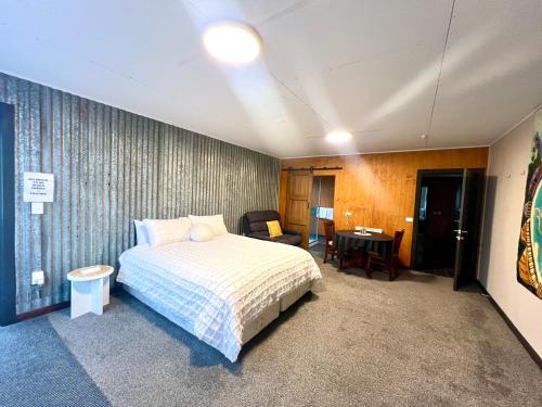 a bedroom with a bed and a chair and a desk at The Barnhouse Getaway in Roslyn Bush