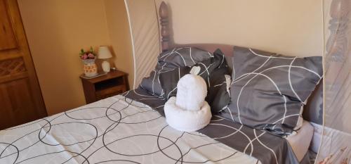 a stuffed animal is sitting on a bed at Vue mer et montagne in Vieux-Habitants