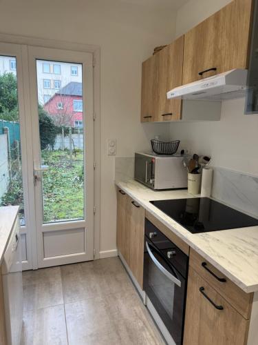 une cuisine avec un évier et une cuisinière four supérieur dans l'établissement Mancelle proche du circuit 24h, au Mans