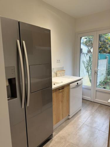 Il comprend une cuisine équipée d'un réfrigérateur en acier inoxydable et une fenêtre. dans l'établissement Mancelle proche du circuit 24h, au Mans