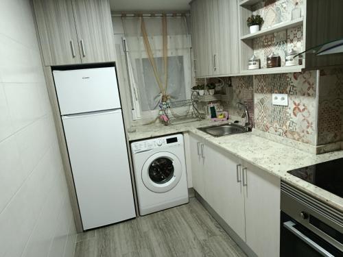 Una cocina con un frigorífico blanco y una lavadora. en San Andres 14, en Teruel