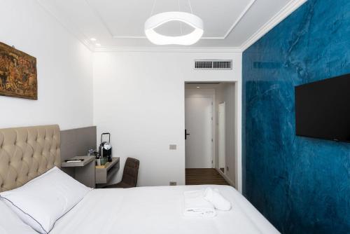 a bedroom with a white bed and a blue wall at Corte dell'Albero in Florence