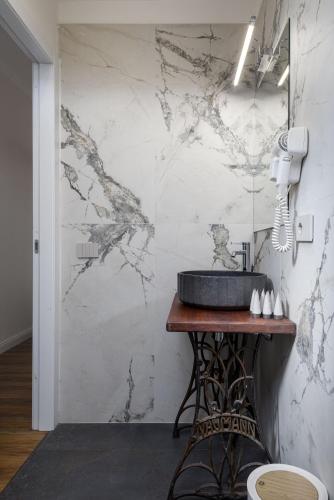 a bathroom with a sink and a marble wall at Corte dell'Albero in Florence