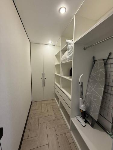 a bathroom with a walk in closet with white cabinets at Торайгырова 89 in Pavlodar
