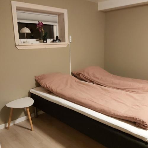 a bed in a room with a window and a table at Experience unique Faroe Islands holiday home by the sea with great views, fully equipped kitchen and reliable Wi-Fi in Norðragøta
