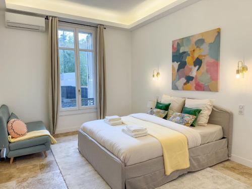 une chambre avec un grand lit et une chaise dans l'établissement Grand appartement rénové - Jardin et Parking - CZ, à Cannes