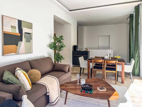 un salon avec un canapé et une table dans l'établissement Grand appartement rénové - Jardin et Parking - CZ, à Cannes