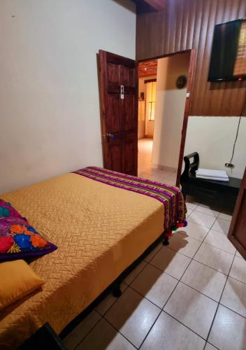 a bedroom with a bed and a tv in it at AZURA HOTEL BOUTIQUE in Cobán