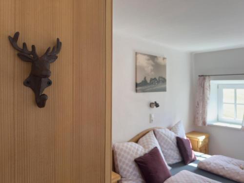 a bedroom with a couch and a deer head on the wall at Ferienhaus Oberpremgut in Krispl