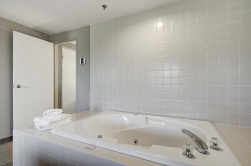 a white bath tub in a bathroom with a mirror at Whitefish Riverfront Hotel in Whitefish