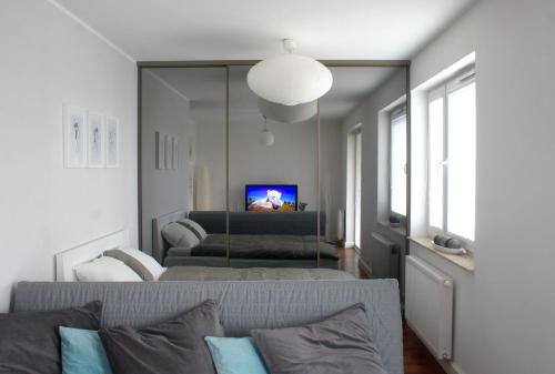 ein Wohnzimmer mit einem Sofa und einem TV in der Unterkunft Apartament-31 in Danzig